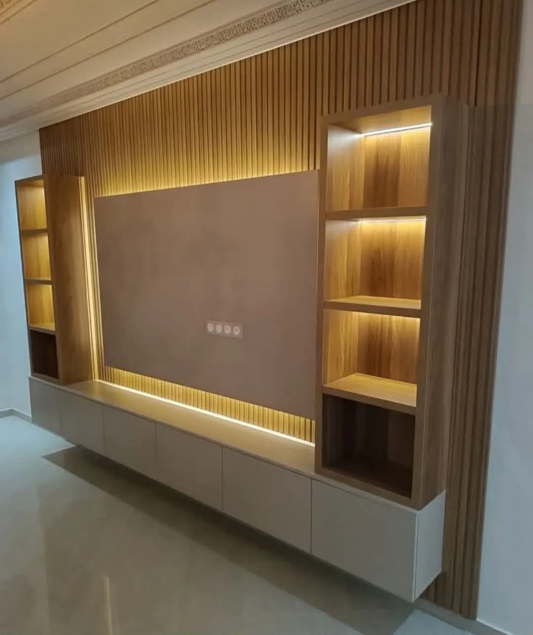 Panel de TV en madera con repisas iluminadas y mueble bajo flotante