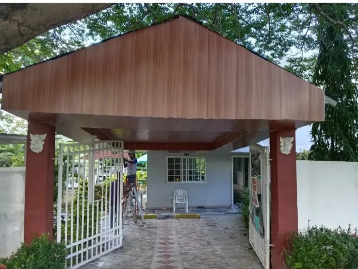 Porche de entrada techado con cielo raso en madera y columnas