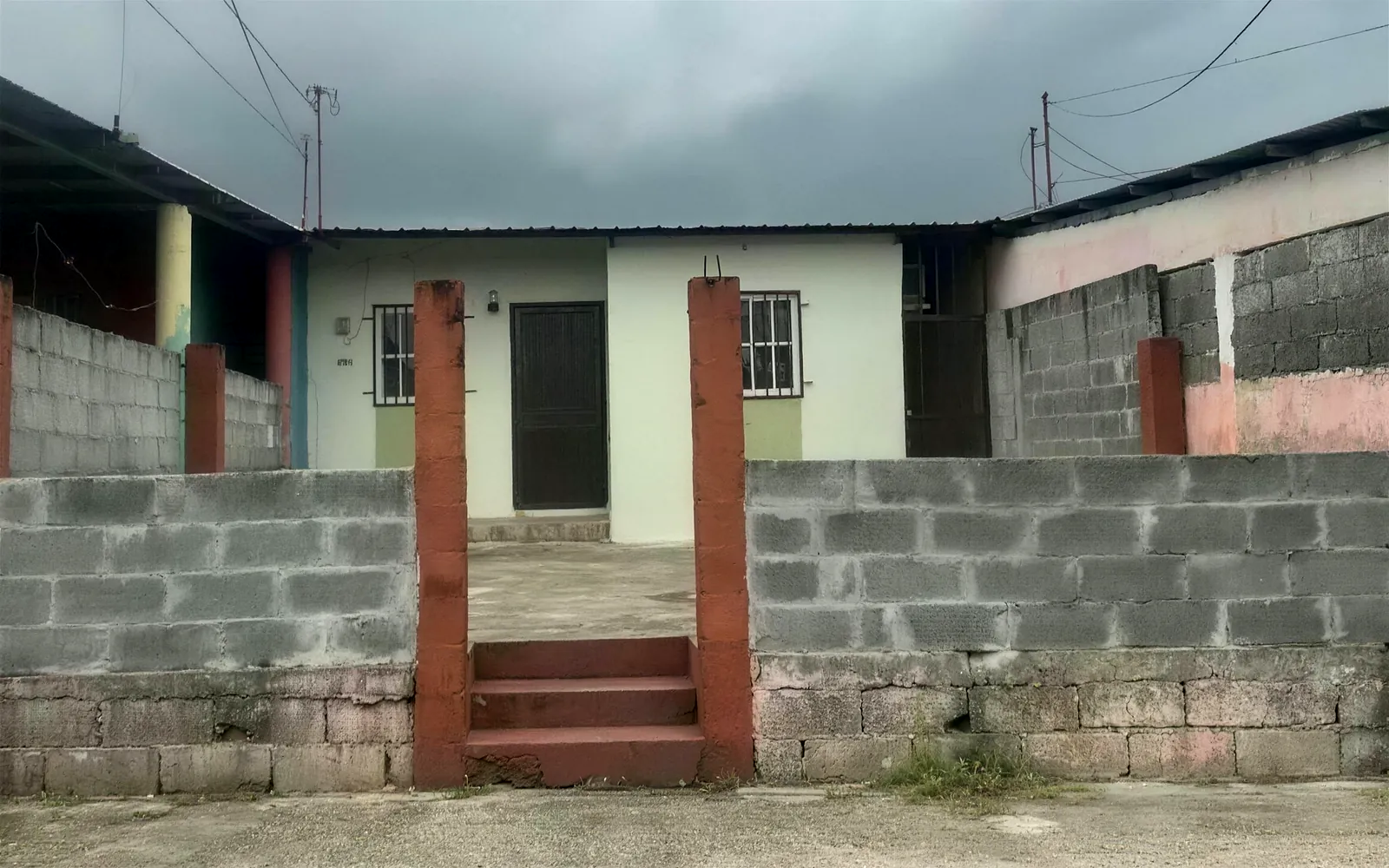 Antes: patio a la intemperie con paredes en bloque sin repellar y escalones deteriorados