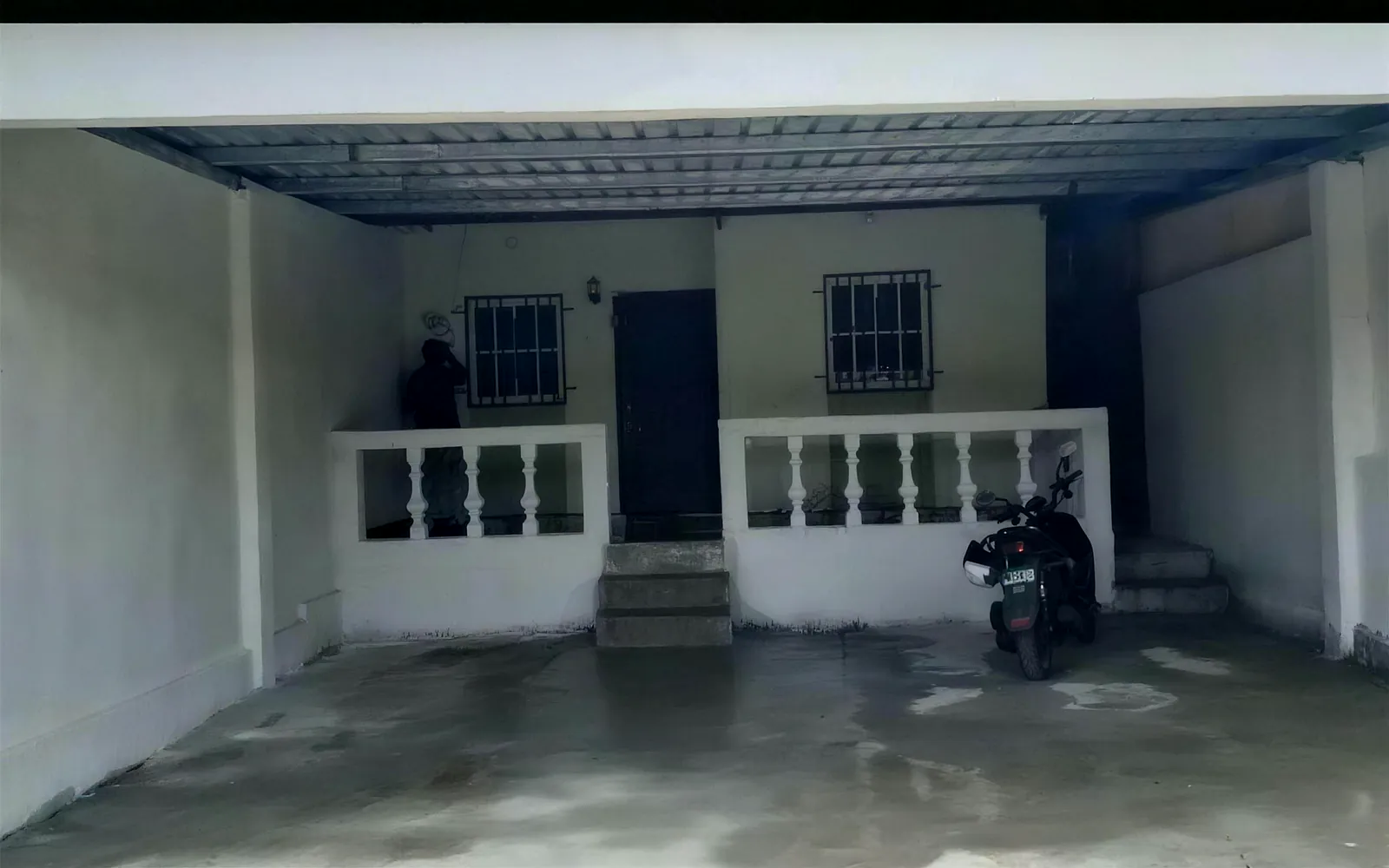 Después: el mismo patio convertido en área techada, repellada y pintada, con balaustrada y piso terminado