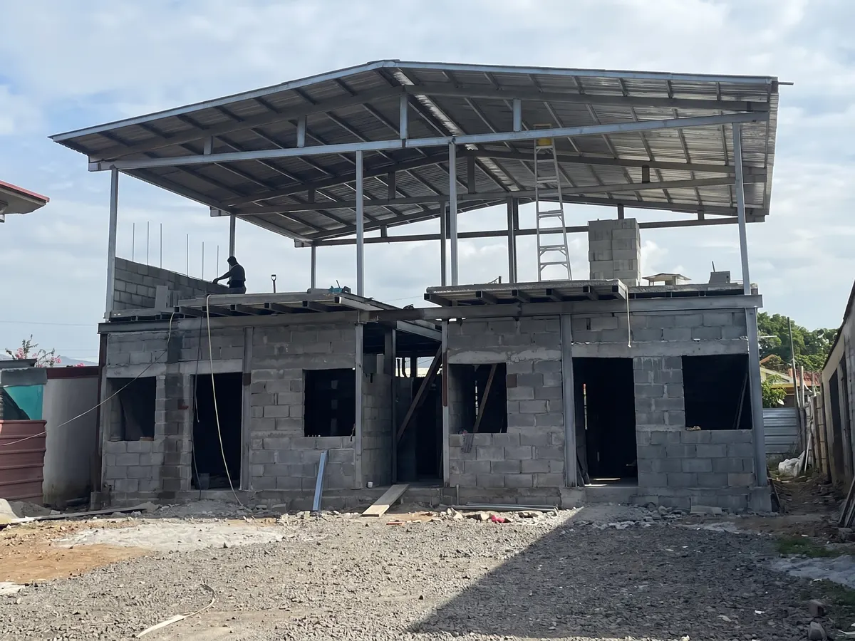 Edificio multifamiliar en obra gris con cubierta metálica instalada