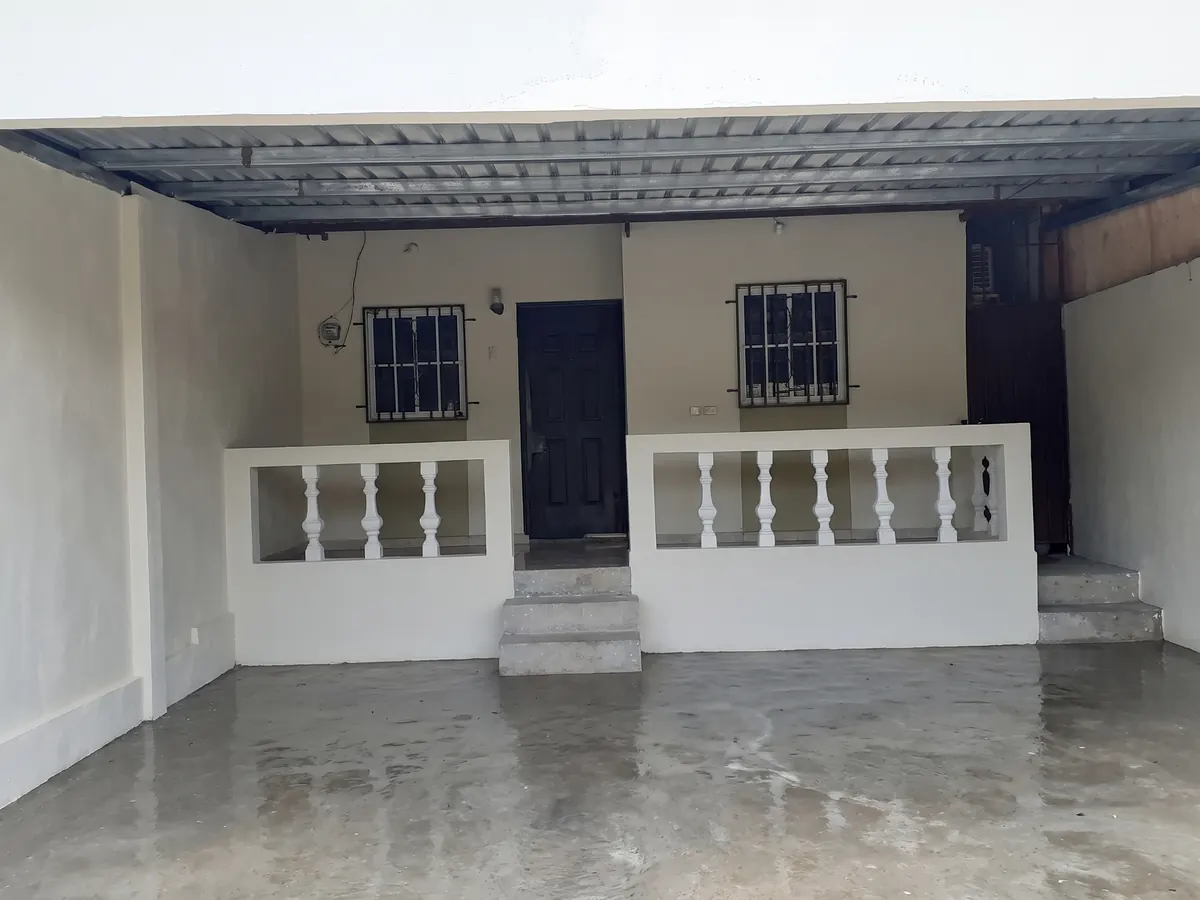 Patio convertido en área techada con paredes repelladas, pintadas y balaustrada